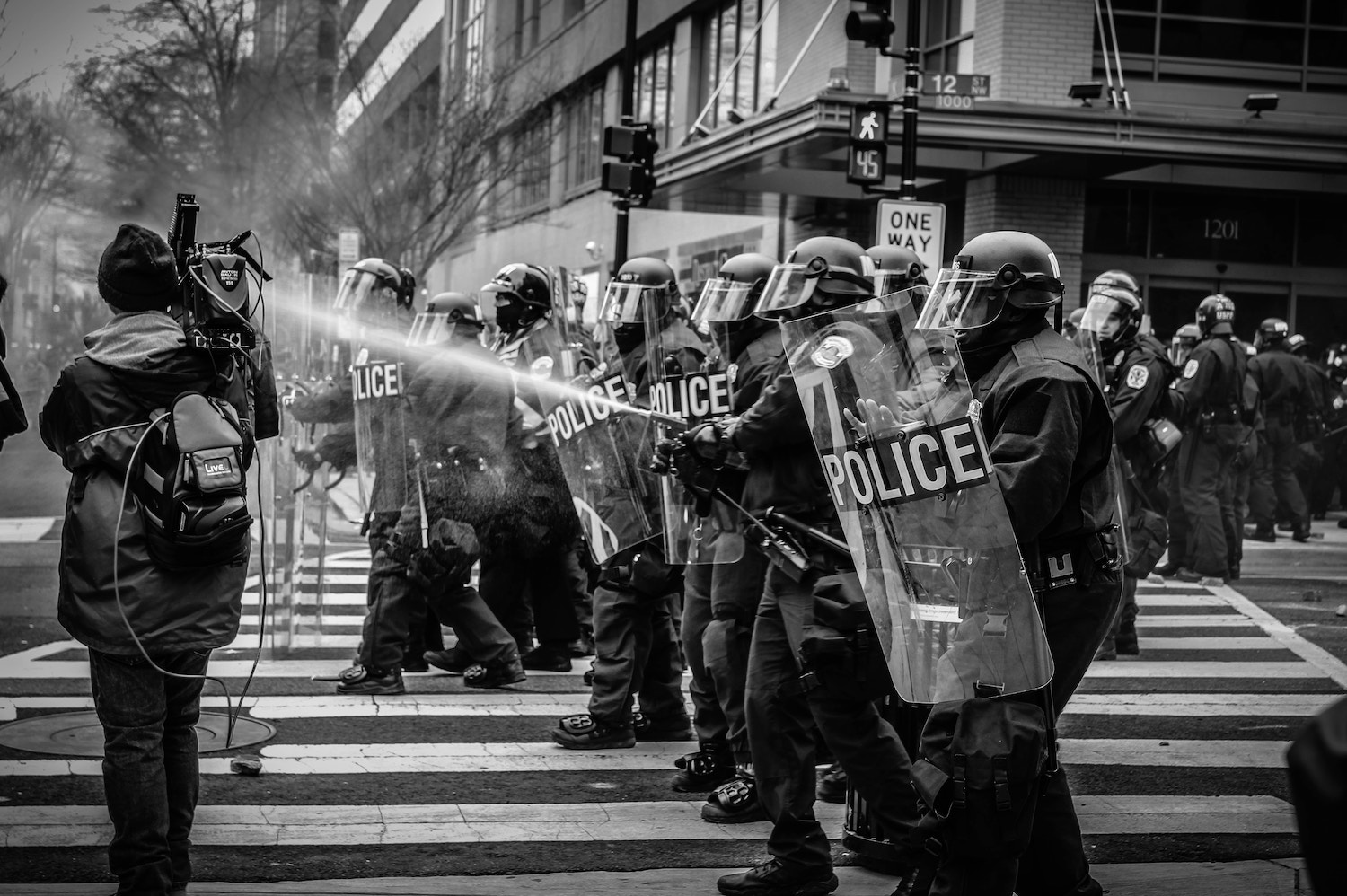 police marching in riot gear spray protestors with tear gas - for just world hypothesis article